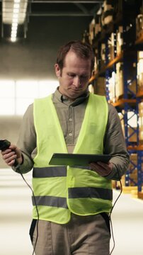 Vertical Video Professional staff scanning barcodes during order fulfillment process. Warehouse management system overseeing inventory for reliable e-commerce shipping and global delivery operations.