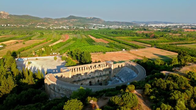 Aerial view of Aspendos Theatre and hills. Drone captures the Roman amphitheater in Antalya during a clear sunny day.