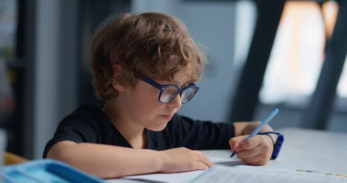 Boy Engrossed In Workbook Tasks. Young Student Analyzing Exercises With Thoughtful Expression