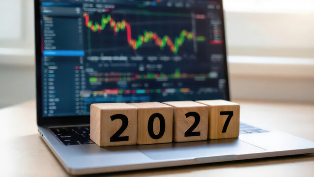 Wooden cubes showing 2027 on laptop keyboard with trading charts stock market volatility analysis dashboard financial data analytics platform quantitative finance models predictive market modeling