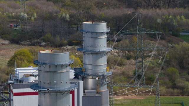Aerial view of the Trianel Gaskraftwerk Hamm power plant featuring industrial chimneys and high-voltage power lines surrounded by green forest in Hamm, Nordrhein-Westfalen, Germany.