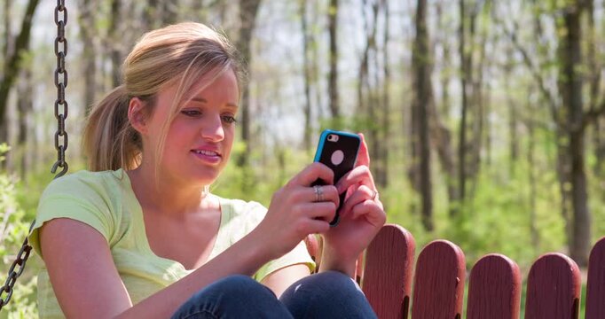 Female outside on cell phone smiling 4k
