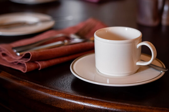White Coffee Cup on Wooden Table with Napkin and Cutlery &ndash; Cozy Restaurant Setting