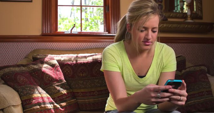 Female sitting on couch texting 4k
