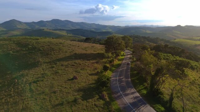 Drone capturando o movimento de autom&oacute;veis  estrada sinuosa entre morros da Serra da Mantiqueira.	
