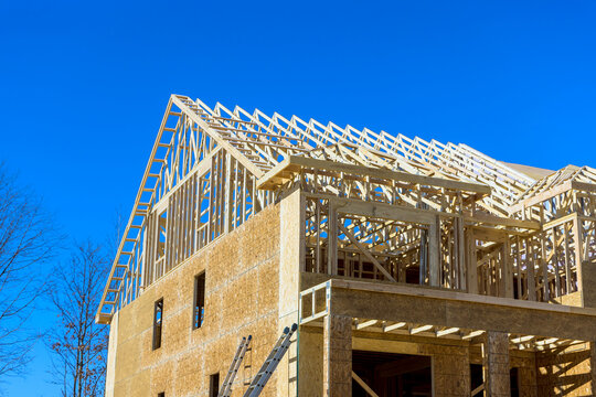 Wooden beams frame building under joists roofing with during construction work.