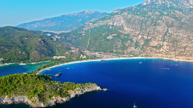 Drone view of Oludeniz Blue Lagoon, Turkey coast. Deep blue sea, green hills and sunny shoreline create a scenic vacation view.