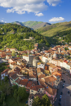 Aerial view of the circular historic center of Borgo Rotondo with its colorful houses and the Fieschi Castle tower, Varese Ligure, Liguria, Italy.