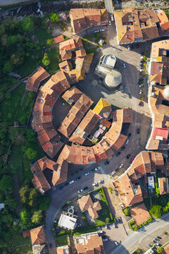 Aerial view of the unique circular layout of Borgo Rotondo with its red-tiled rooftops and historic stone tower in Varese Ligure, Liguria, Italy.