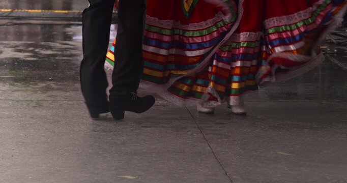 Man and woman dance wearing traditional Mexican costume colourful skirt feet close up
