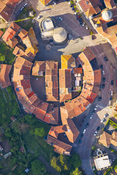 Aerial view of the circular Borgo Rotondo historic center with its unique ring of colorful houses and terracotta rooftops in Varese Ligure, Liguria, Italy.