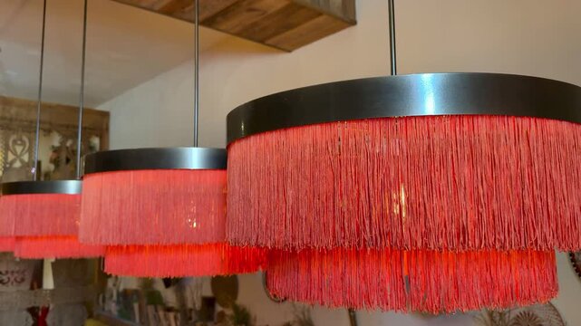 Red Fringe Lampshades Hanging Over Restaurant Tables, Warm Golden Glow, Velvet Tassels, Shallow Focus, Blurred Seating, Intimate