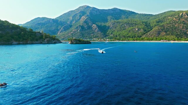 Drone view off Oludeniz Blue Lagoon, Turkey. Open water, distant boats and green coast create a peaceful summer travel scene.