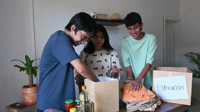 Young people preparing donation boxes with food and clothing