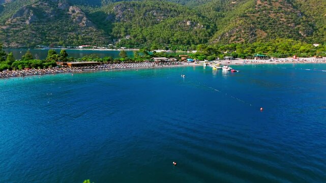 Drone view of Oludeniz Blue Lagoon, Turkey bay. Small boats, blue water and green mountains create a sunny summer travel scene.