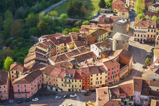 Aerial view of the historic Borgo Rotondo with its unique circular layout of colorful houses and the medieval stone tower in Varese Ligure, Liguria, Italy.
