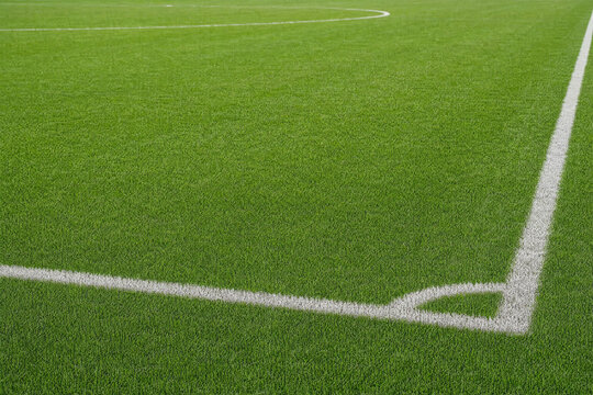 White lines on a green artificial turf soccer field at a sports stadium, corner kick area for football match training and athletic competition background for sports concept