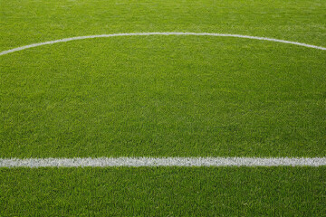 Obraz premium High angle view of a lush green soccer field with white painted lines and center circle, professional football pitch for sports competition, match day, and athletic training