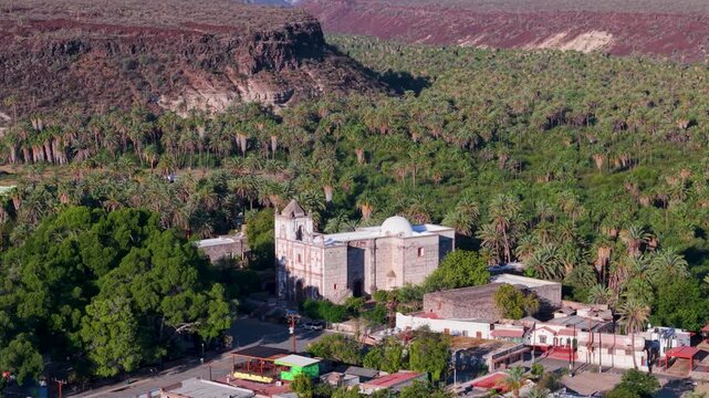 Discover aerial views of Mission Church located in San Ignacio oasis in Baja California, Mexico surrounded by lush landscape and history.