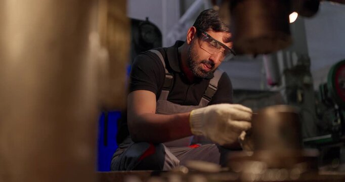 Technician Inspecting Precision Metal Component in Industrial Workshop