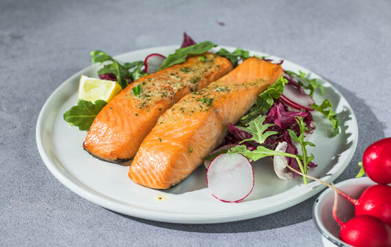 Salmon. Fried salmon steak with red radicchio cabbage, radish and arugula.