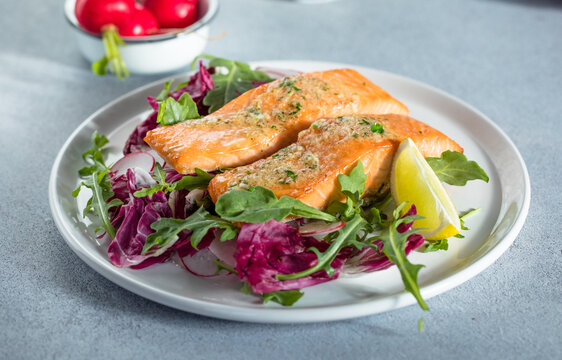 Salmon. Fried salmon steak with red radicchio cabbage, radish and arugula.
