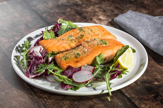 Salmon. Fried salmon steak with red radicchio cabbage, radish and arugula.