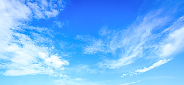 Panoramic vibrant blue sky background with soft white clouds and bright daylight for natural backdrop and clean outdoor design