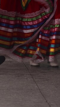 Man and woman dancing traditional Mexican costume colourful skirt feet close up