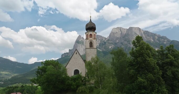 Aerial of St. Constantine Church with Schlern Mountain in the background, Dolomites, Italy
