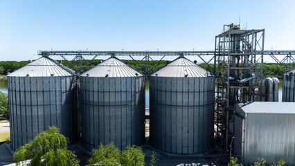 Large industrial grain silos with processing tower at a riverside facility © Amatis Art