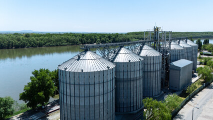 Aerial view of industrial grain silos and terminal located on a river bank © Amatis Art