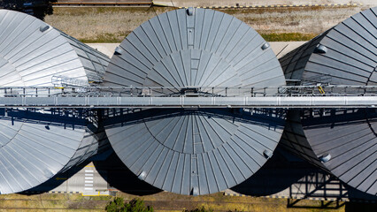 Top down aerial view of circular metal grain silos and conveyor bridge © Amatis Art