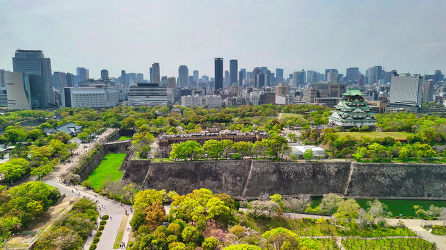 Majestic Osaka Castle surrounded by modern skyscrapers from above