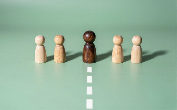 Wooden figures stand in line one darker center figure leads the group.