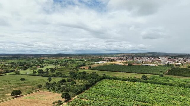 Panorama a&eacute;reo capturando a transi&ccedil;&atilde;o entre &aacute;reas rurais de cultivo, com destaque para planta&ccedil;&otilde;es de banana, e o centro urbano da cidade de Utinga, localizada na regi&atilde;o da Chapada Diamantina, Bahia.