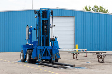 Blue forklift with long forks parked outside warehouse © SNEHIT PHOTO