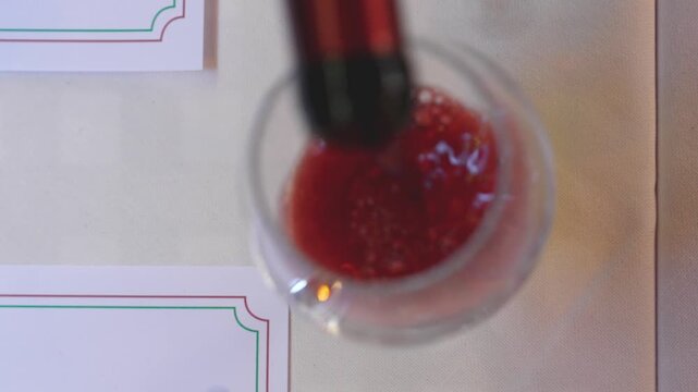 Waiter elegantly filling wine glass during dinner service
