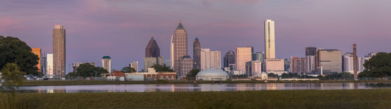 View of the Downtown Atlanta Skyline Cityscape showing several prominent buildings, highways, cars, and hotels after sunset.	