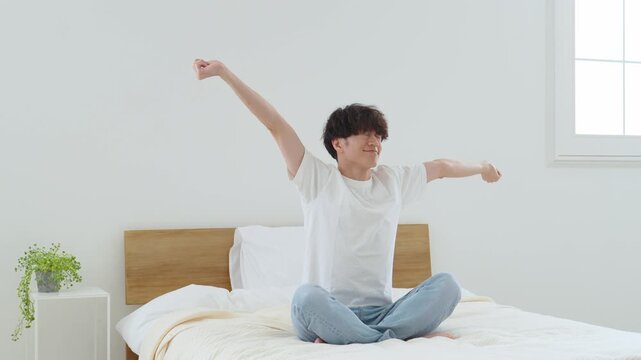 ベッドの上でストレッチをする男性