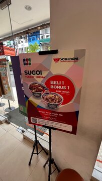 Yoshinoya Japanese Restaurant promotional standee featuring Sugoi Yummy Friday BOGO offer for JCB cardholders at a Kuta storefront - Bali, Indonesia, March 29, 2023
