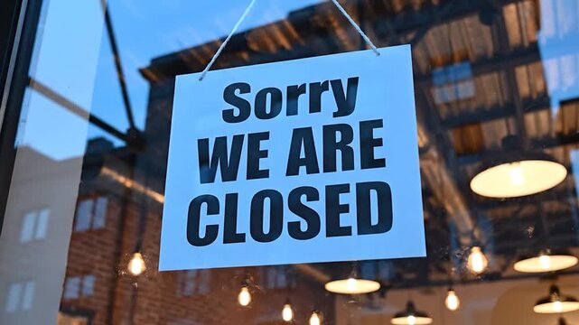 A sign that says 'Sorry We Are Closed' is displayed in the window of a commercial establishment, indicating temporary unavailability