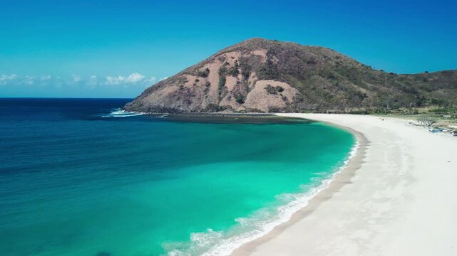 Aerial drone view of Mawun Beach Lombok Indonesia showing horseshoe bay with white sand turquoise waters and green headlands