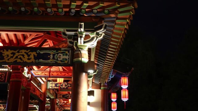 Traditional Chinese architectural eaves and dougong brackets with colorful paintings illuminated at night