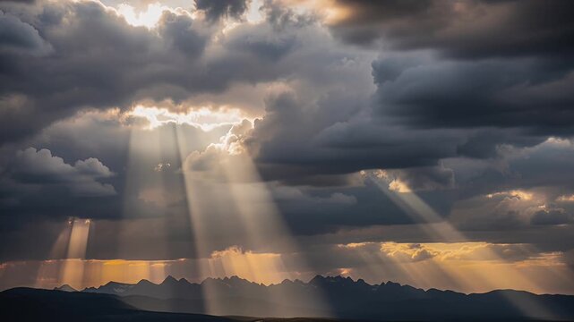 sunbeams through dramatic clouds over distant mountains
