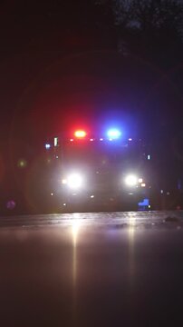 Vertical 4K video of flashing red and blue lights of a fire truck at night.
