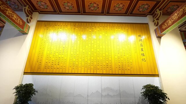 Traditional Chinese entrance corridor featuring golden plaque and carved wooden lattice windows