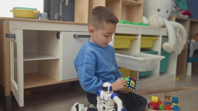 Hispanic boy kneeling holds green toy train and inspects a small block in playroom; curiosity play learning.