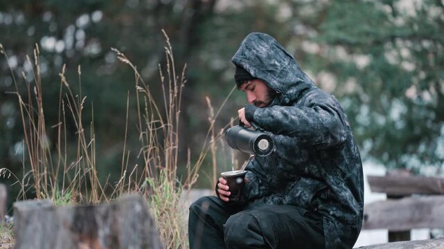 Man drinking mate in cold outdoor setting, conveying solitude, reflection and quiet lifestyle storytelling in nature.