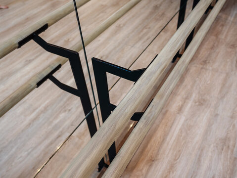 Close up of wooden Pilates barre and mirrored studio interior in modern fitness space